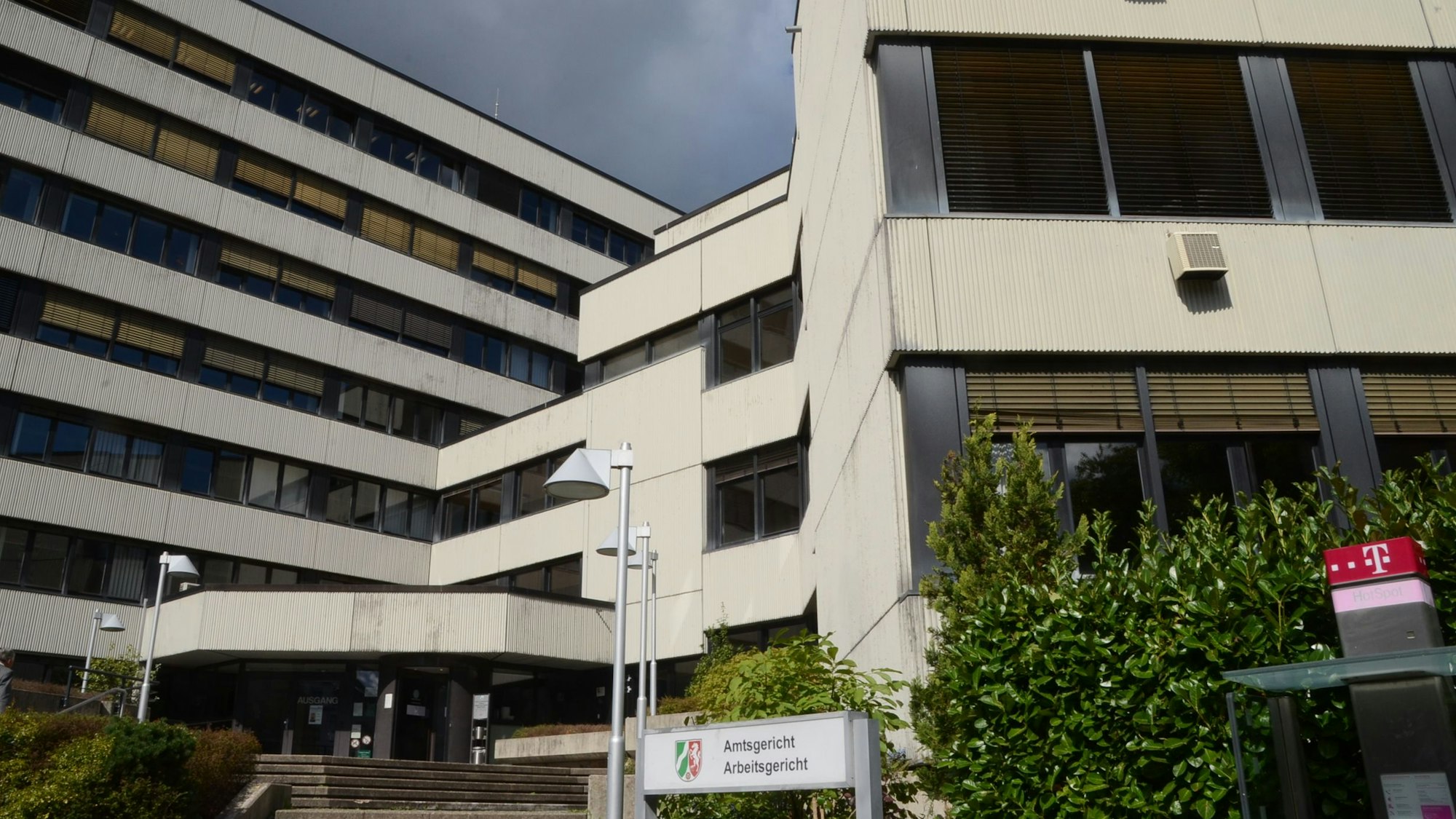 Das Amtsgericht Siegburg, ein weißes mehrstöckiges Gebäude mit einem Treppenaufgang und einem Schild.