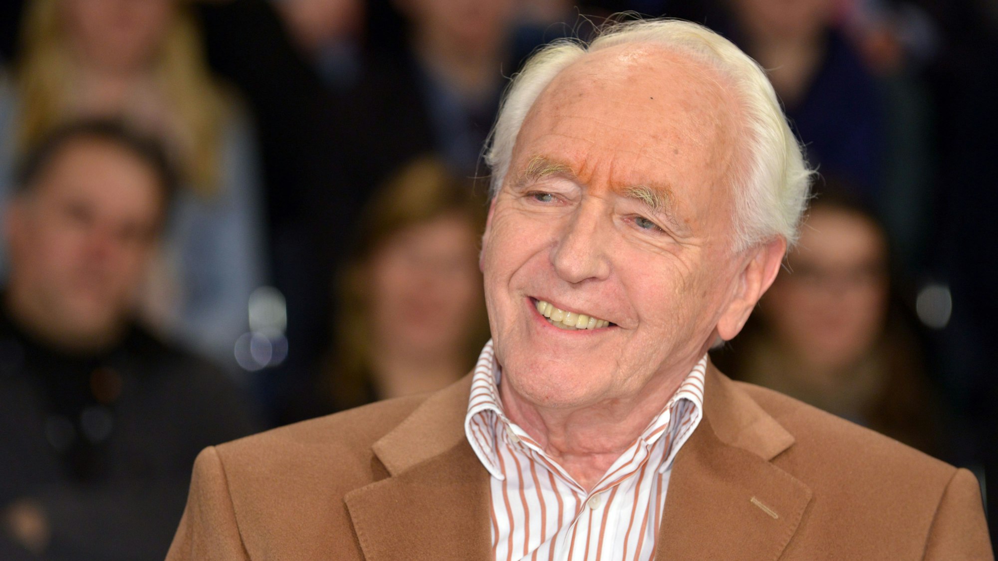 Wolf Schneider, Journalist und Autor, sitzt in einer Talkshow und lächelt mild.