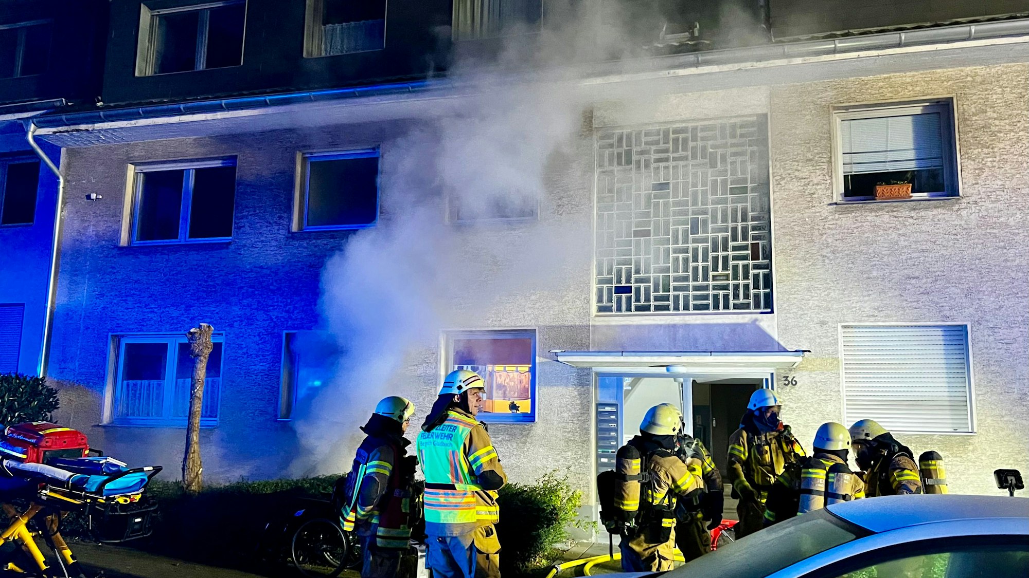 Aus einem Haus steigt Qualm auf. Vor dem Haus stehen mehrere Feuerwehrleute.