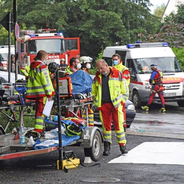 Uniformierte Helfer der DLRG und des DRK stehen mit ihren Fahrzeugen beim Hochwasser-Einsatz am 15. Juli 2021 in Leichlingen auf der Straße.