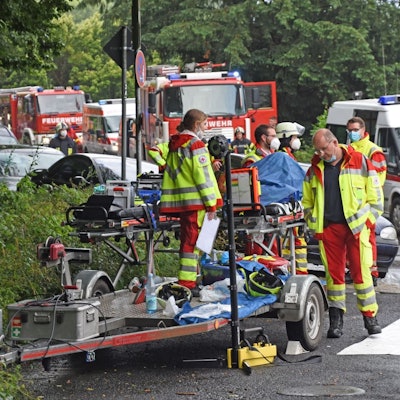 Uniformierte Helfer der DLRG und des DRK stehen mit ihren Fahrzeugen beim Hochwasser-Einsatz am 15. Juli 2021 in Leichlingen auf der Straße.