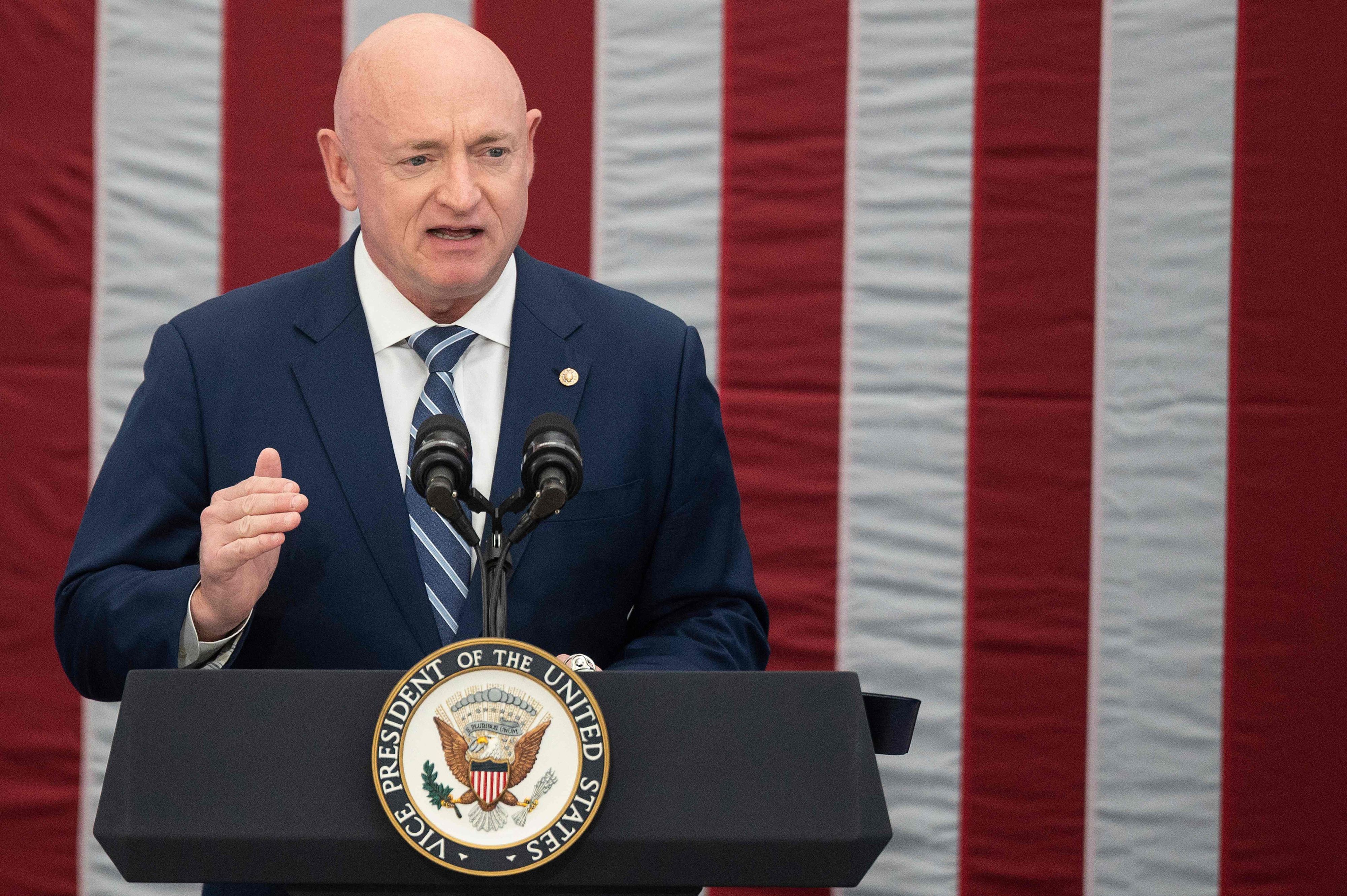 US-Senator Mark Kelly hält eine Rede vor einer amerikanischen Flagge.