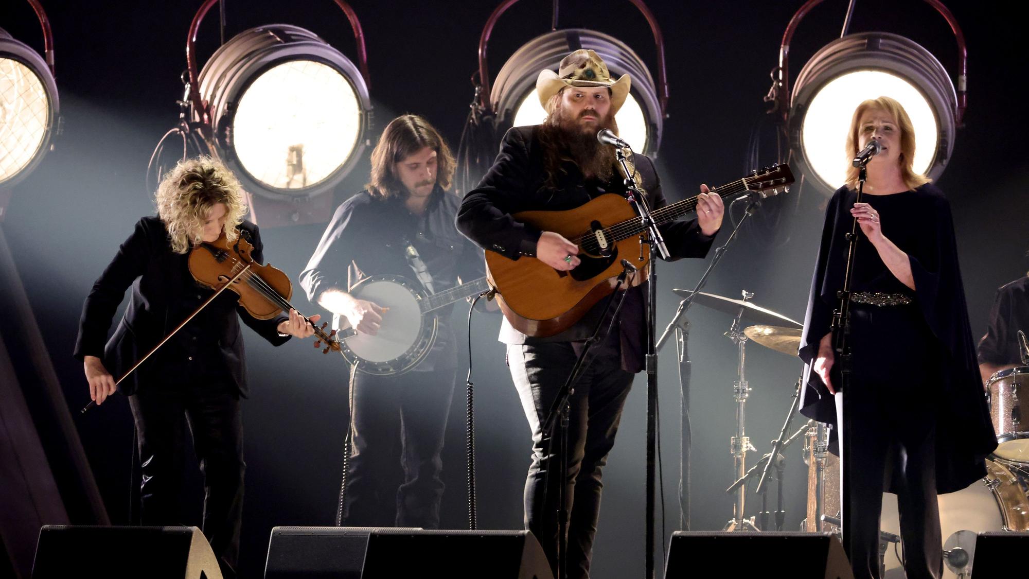 Chris Stapleton spielt auf der Bühne, Patty Loveless singt neben ihm. Daneben Musiker, die spielen.