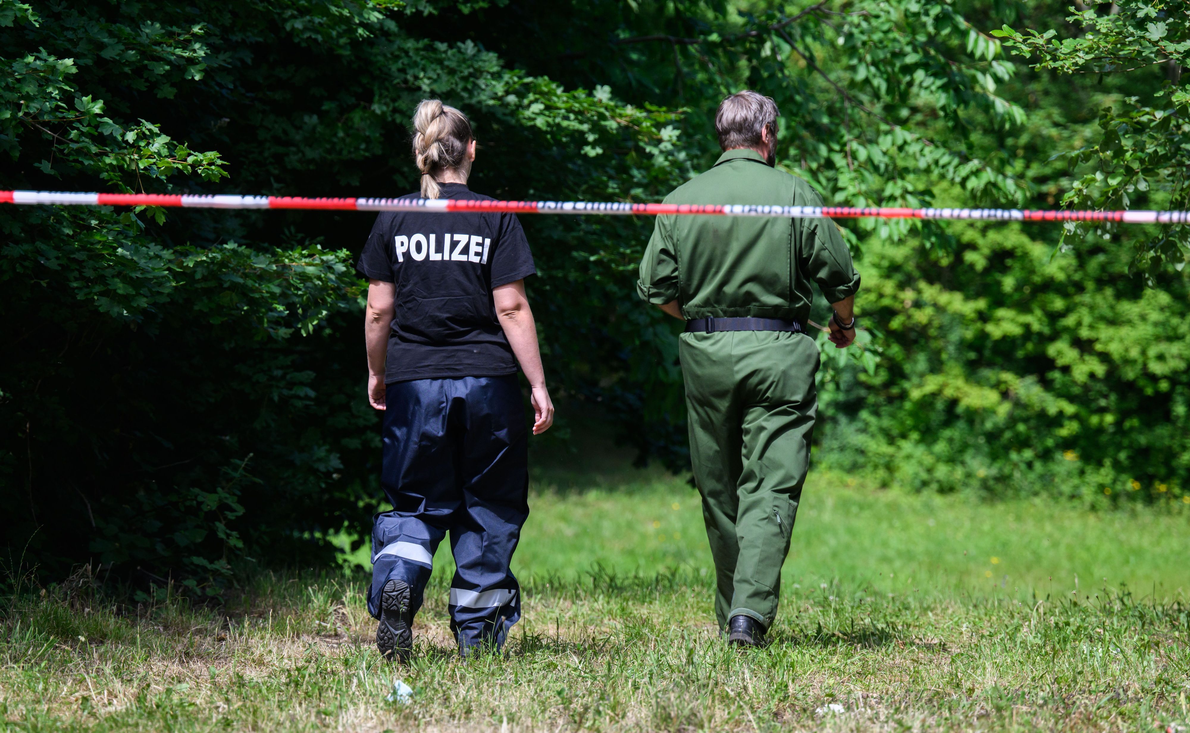 Mitarbeiter der Spurensicherung der Polizei Salzgitter stehen an einem Tatort an einer Grünfläche am Hans-Böckler-Ring.