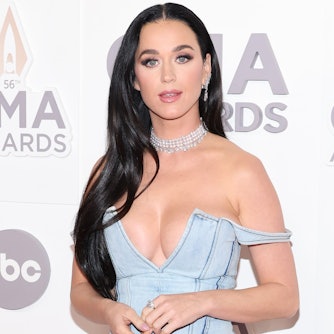 Katy Perry mit üppigem Dekolletee auf dem roten Teppich der CMA Awards. Ein Träger ihres Jeanskleid ist nach unten gefallen. Sie trägt silbernen Schmuck.