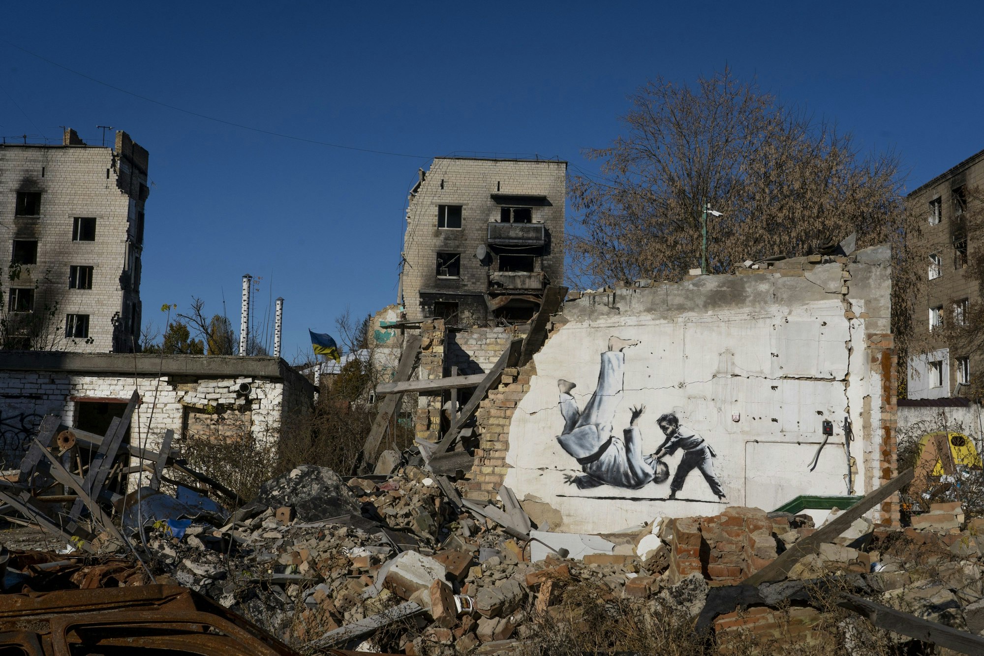 Auf den Überresten einer Hauswand im ukrainischen Ort Borodjanka ist Streetart zu sehen. Ein Junge wirft einen erwachsenen Judoka zu Boden.