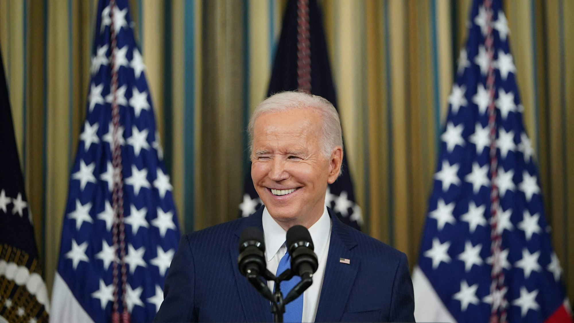 US-Präsident Joe Biden steht am 9.11.2022 während einer Pressekonferenz lächelnd vor US-Flaggen
