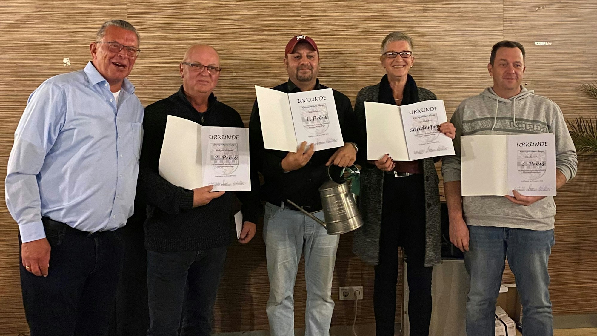 Auf dem zweiten Bild sind alle Gewinner und Herr Korioth vom Standverband Leverkusen Kleingärtner e.V. zu sehen. Von links nach rechts ist zuerst Herr Korioth zu sehen, Dann ein Vertreter für den KGV Holzerwiesen, dann der Gewinner KGV Feierabend, dann der KGV Steinbrüche mit dem Sonderpreis und letztlich der dritte Preis vom Kleingartenverein Heidehöhe.