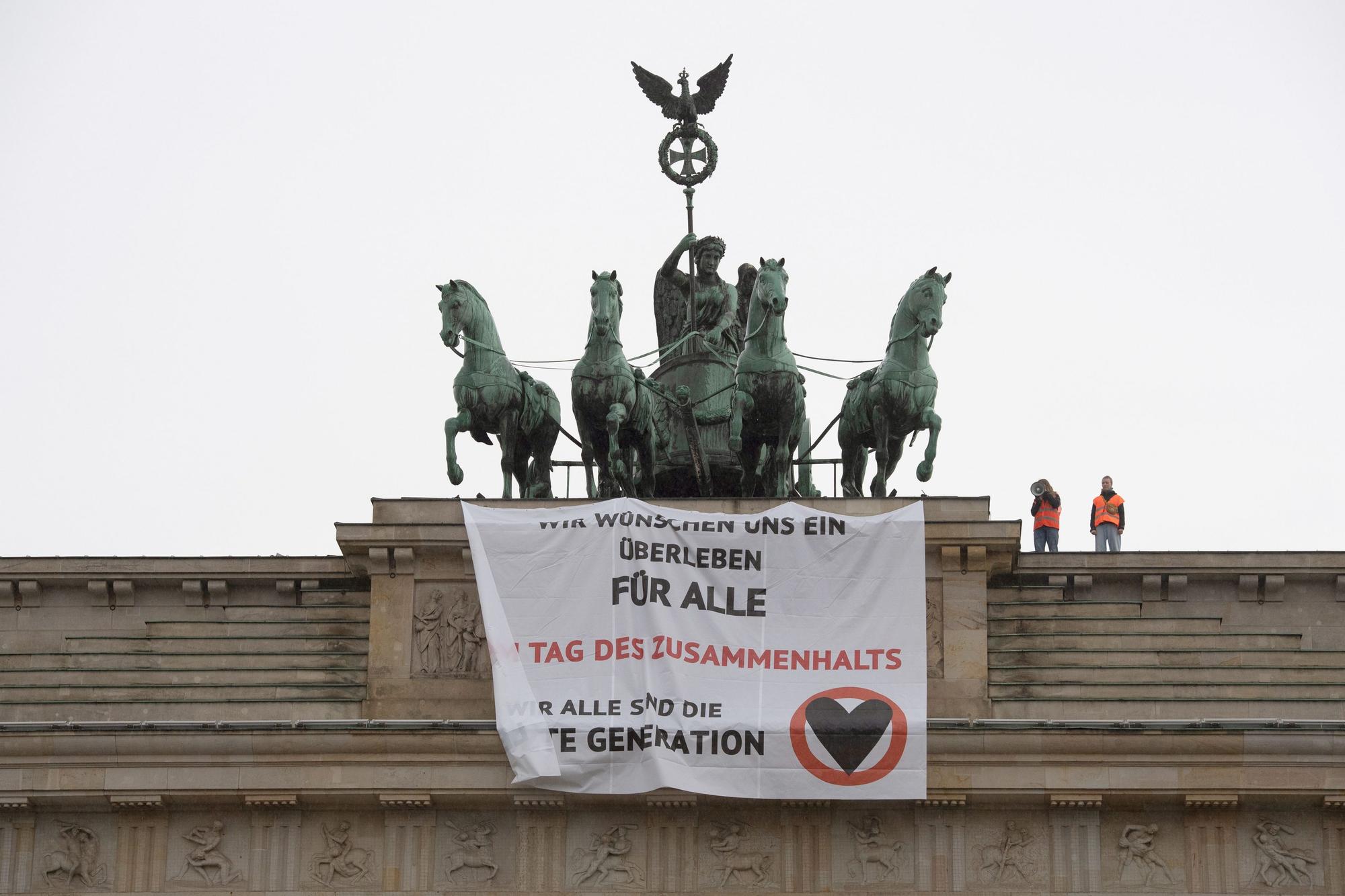 „Wir wünschen uns ein Überleben für alle“ steht auf einem Transparent, das Aktivisten der Gruppe „Letzte Generation“ am 9. November am Brandenburger Tor aufgehängt haben.
