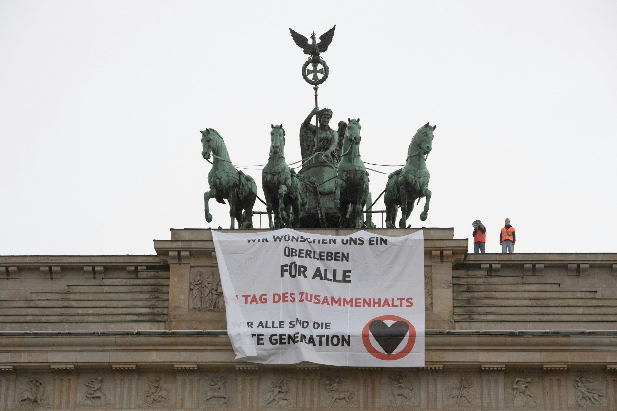 „Wir wünschen uns ein Überleben für alle“ steht auf einem Transparent, das Aktivisten der Gruppe „Letzte Generation“ am 9. November am Brandenburger Tor aufgehängt haben.