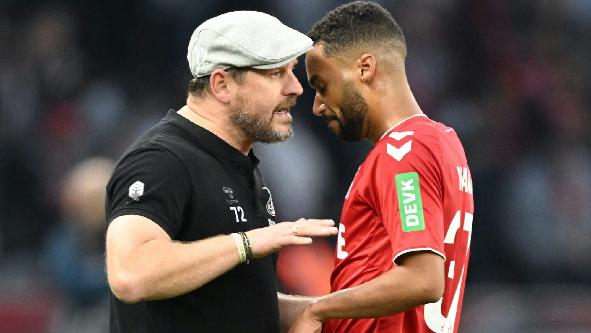 FC-Trainer Steffen Baumgart redet zur Halbzeit des Spiels gegen Hertha BSC noch auf dem Platz auf Angreifer Linton Maina ein, der während des ersten Durchgangs mehrere Großchancen vergeben hatte.