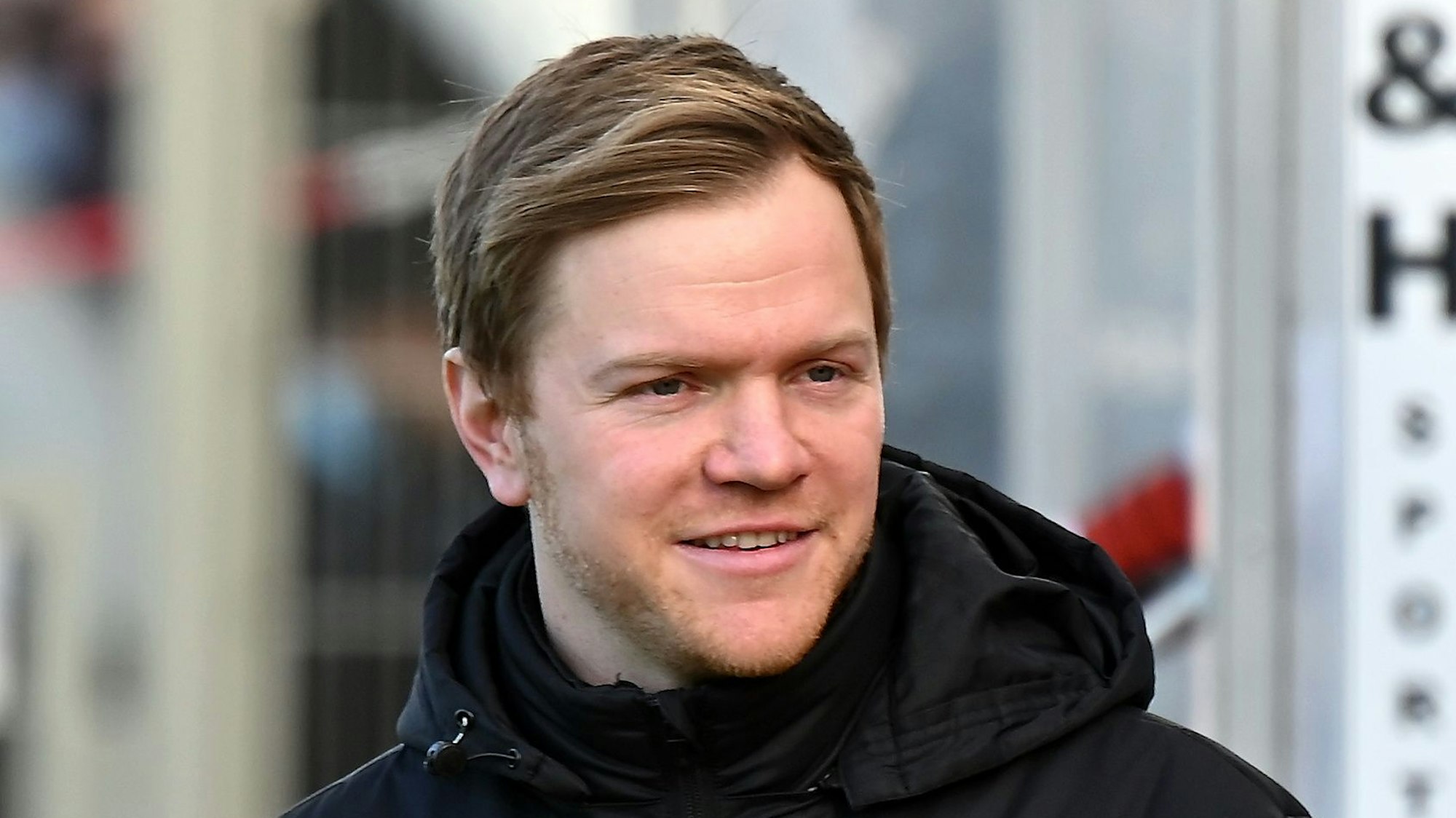 Portät eines Fußballtrainers, der leicht lächelt.