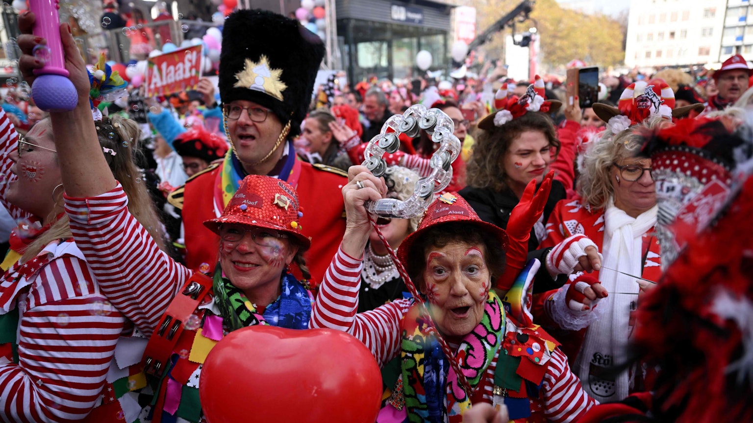 Mehrere Jecken feiern Karneval. Sie sind verkleidet und geschminkt.