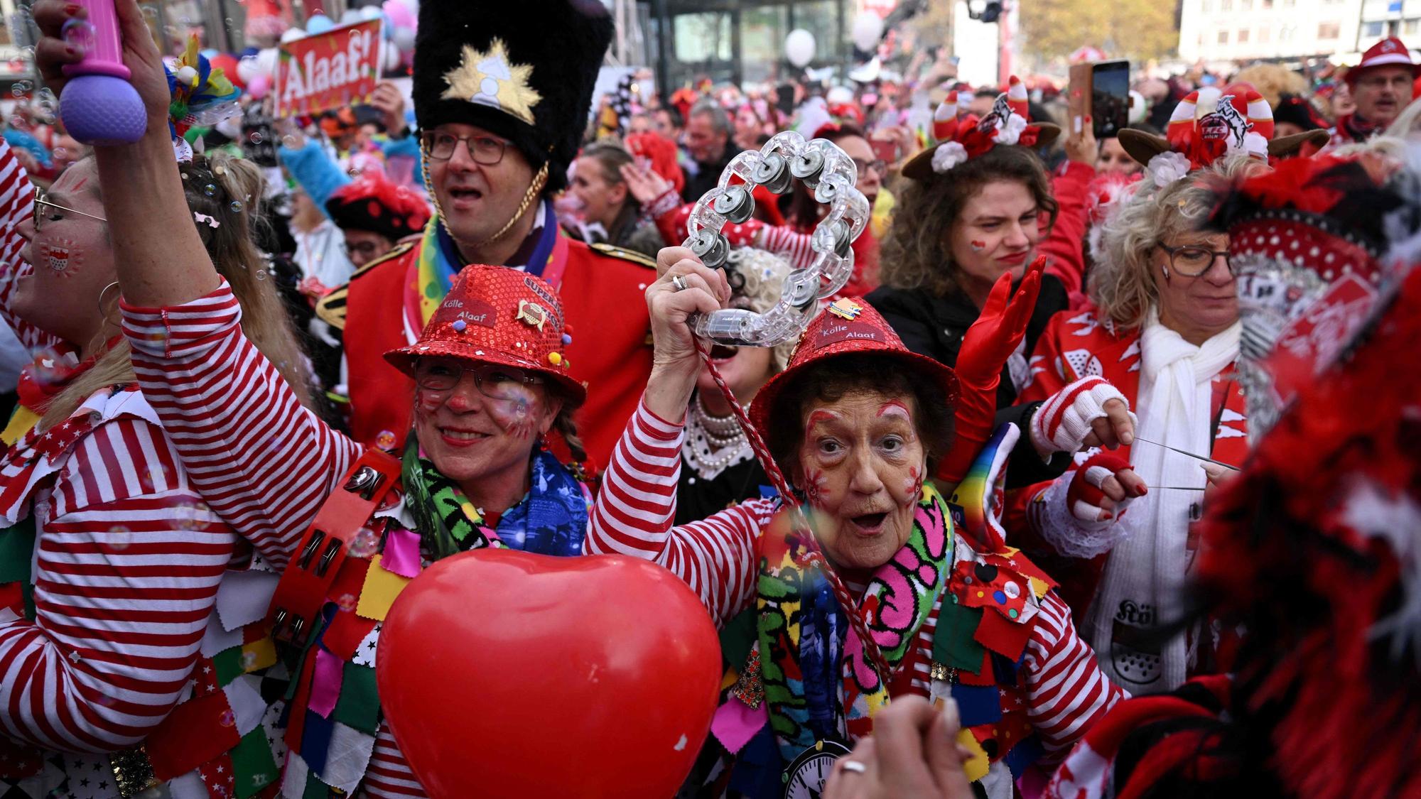 Mehrere Jecken feiern Karneval. Sie sind verkleidet und geschminkt.