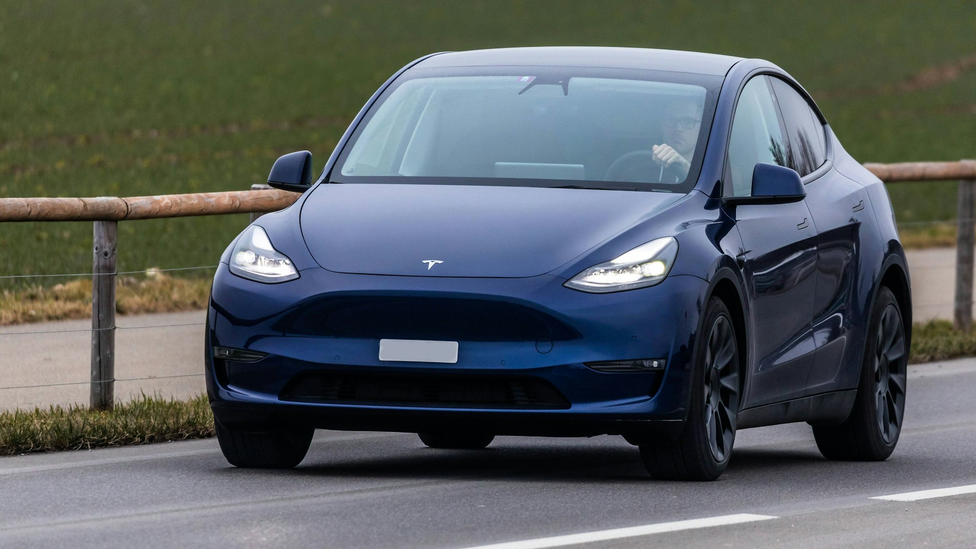 Ein Tesla Model Y fährt auf einer Strasse ausserorts im Zürcher Unterland.