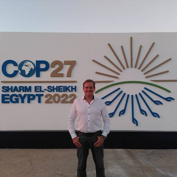 Sven Harten aus Drinhausen steht vor dem Schild der COP27 in Ägypten.