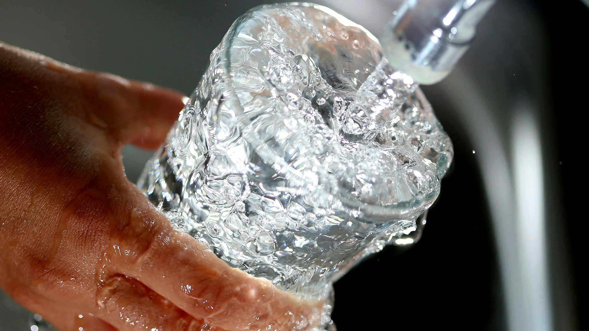 Ein Glas wird mit Wasser gefüllt.