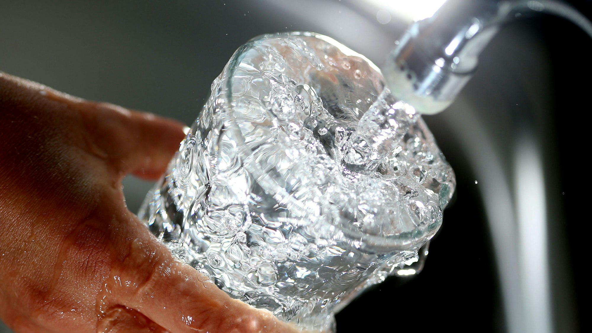 Symbolbild: Ein Glas wird mit Wasser gefüllt.