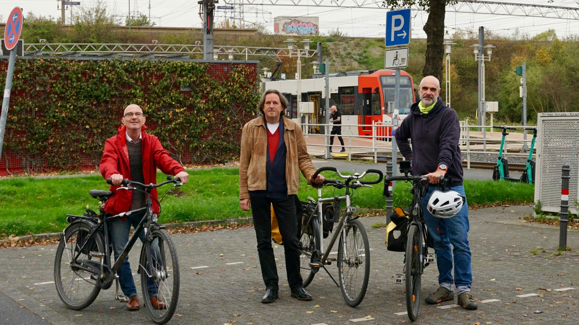 Thomas Roth, Roland Schüler und Axel Fell an der Stelle des Park-and-Ride-Platzes, wo der Kölner Bike-Tower bereits stehen sollte. Im Hintergrund ist eine KVB-Straßenbahn zu sehen.