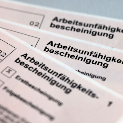 Drei Arbeitsunfähigkeitsbescheinigungen für Arbeitnehmer liegen aufgefächert übereinander.