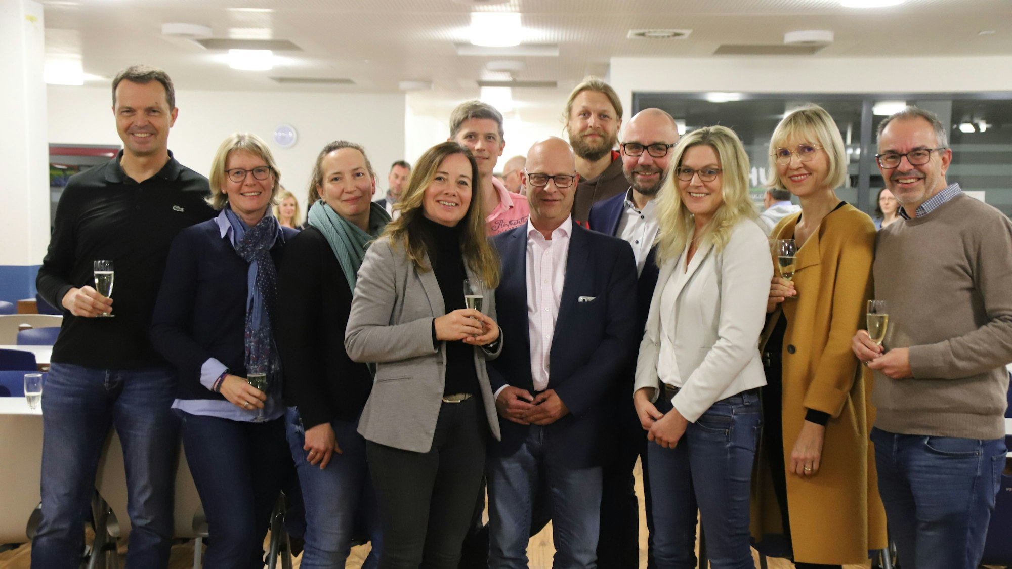 Vorstandsmitglieder und Mitglieder des Fördervereines des Gymnasiums Hennef stoßen zum Jubiläum mit einem Glas Sekt an.