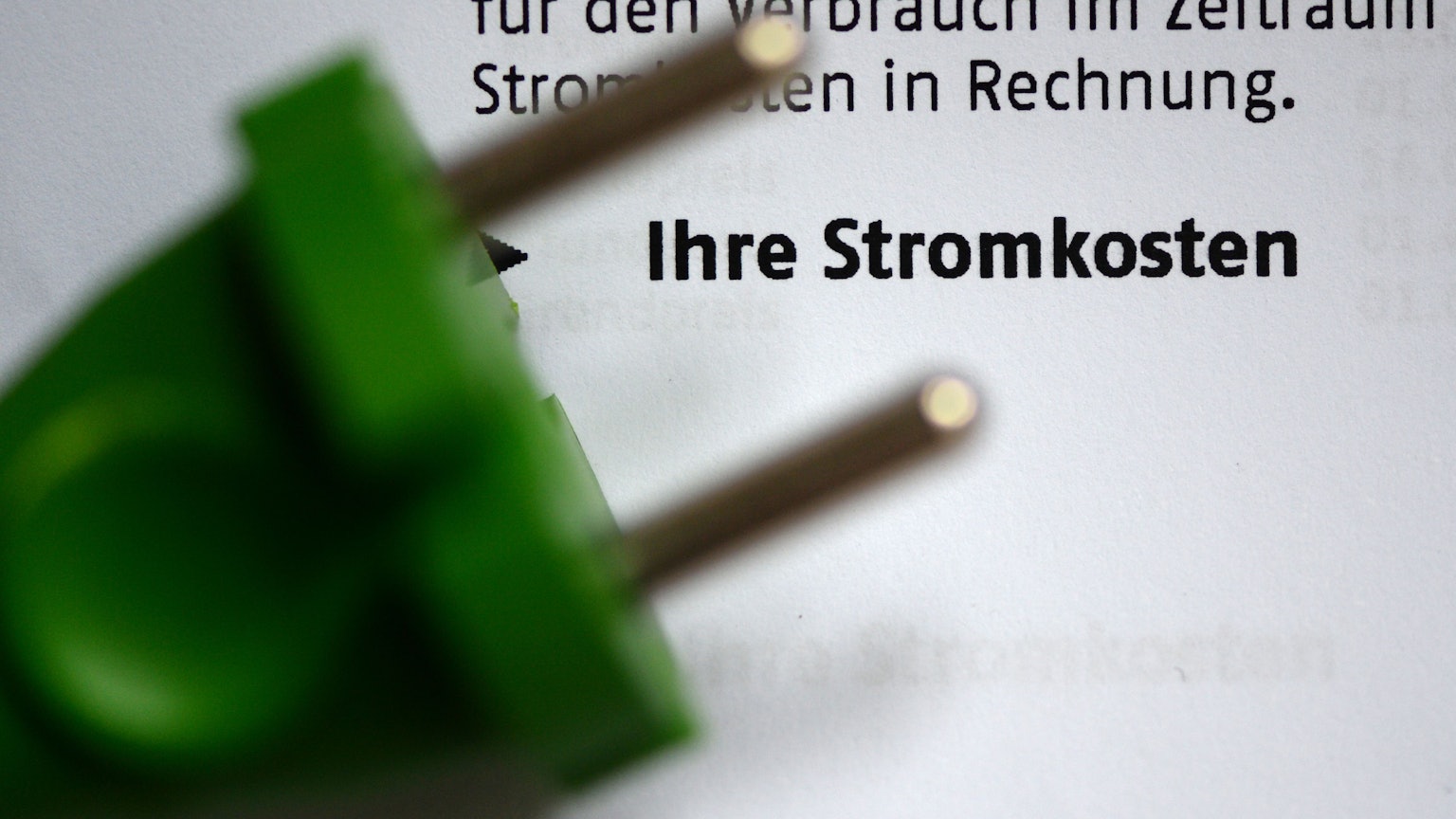 Ein grüner Stromstecker auf einer Stromrechnung.