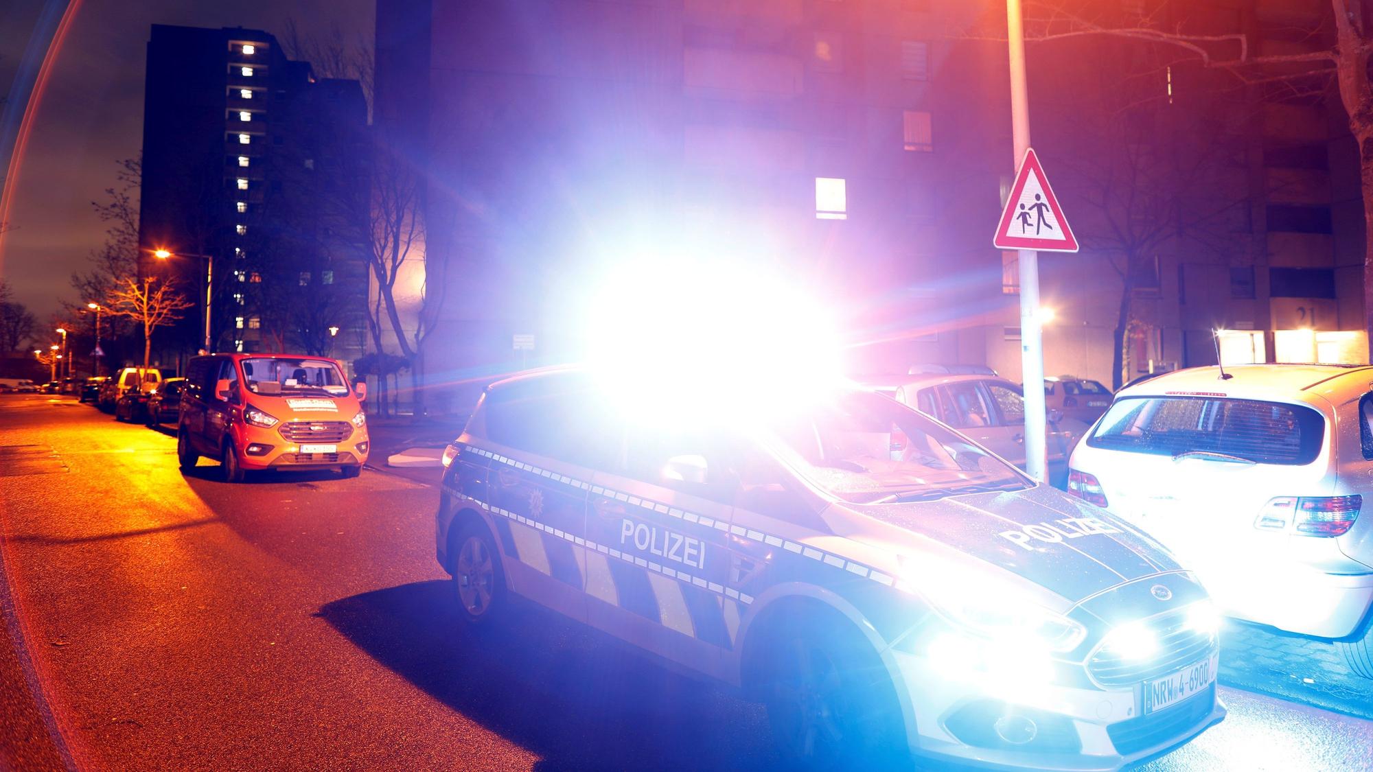 Ein Polizeiwagen steht vor einem Hochhaus im Kölner Stadtteil Chorweiler.
