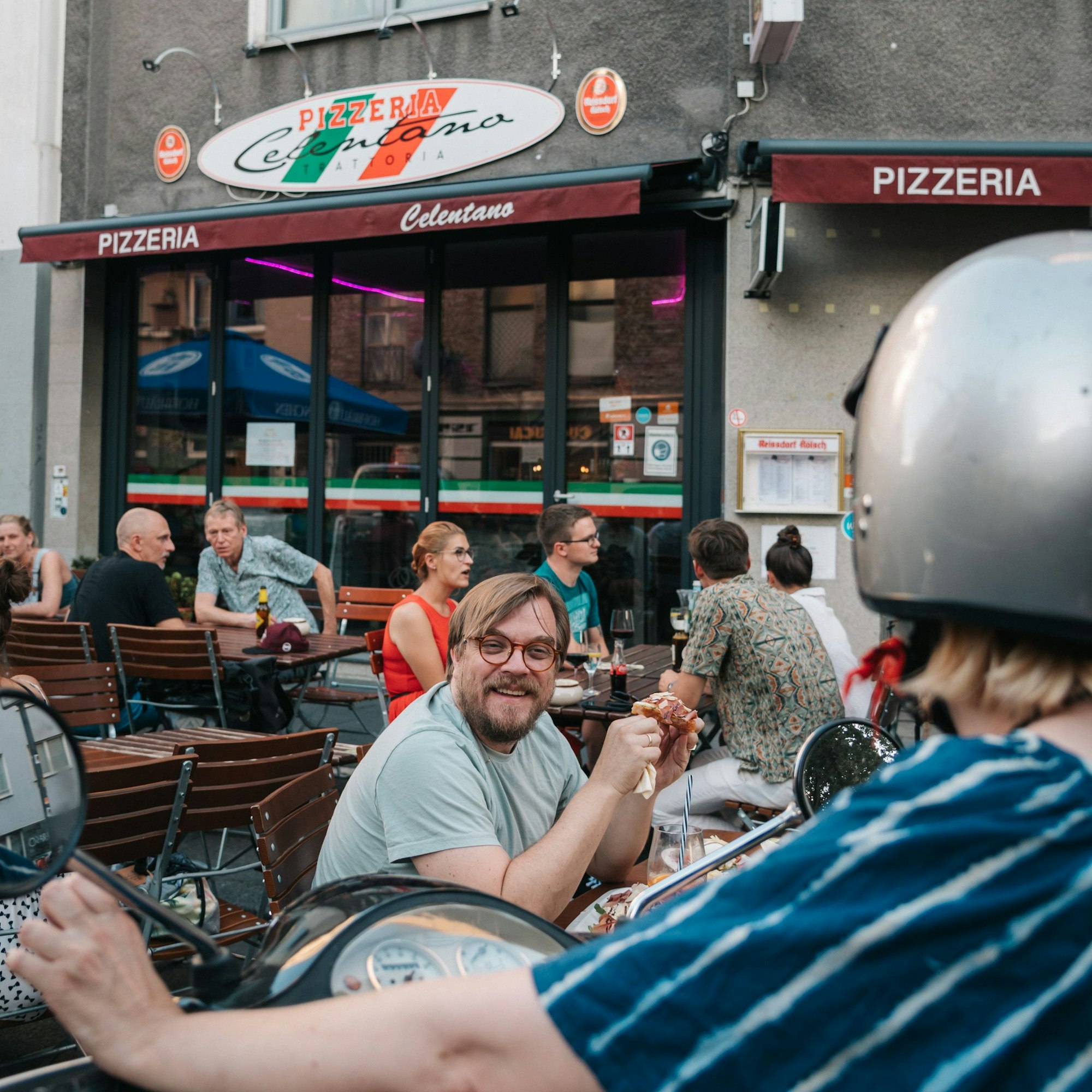 Nilz Bokelberg sitzt vor der Tratorria Celentano in der Kölner Nordstadt.