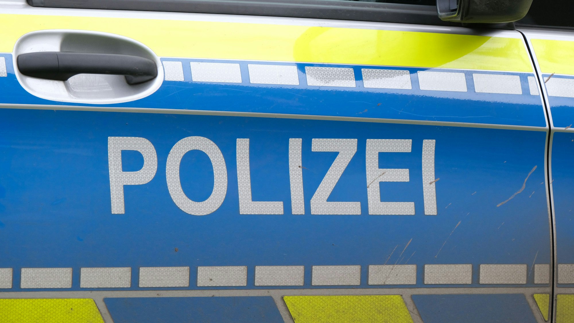 Nahansicht einer Türe eines Polizeiautos mit dem Schriftzug „Polizei“.