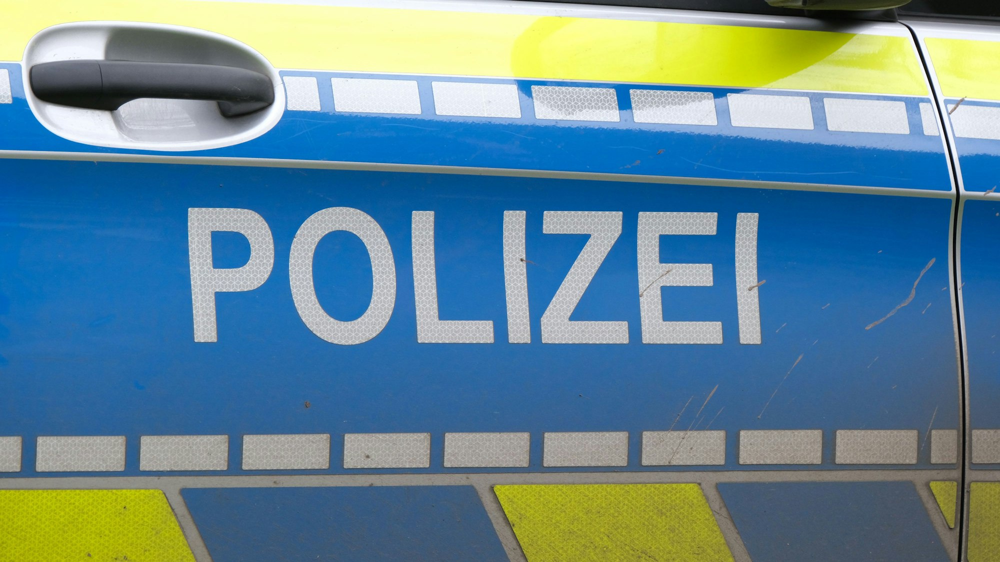 Wagentür eines Polizeiautos mit „Polizei“ Aufschrift (Symbolbild)