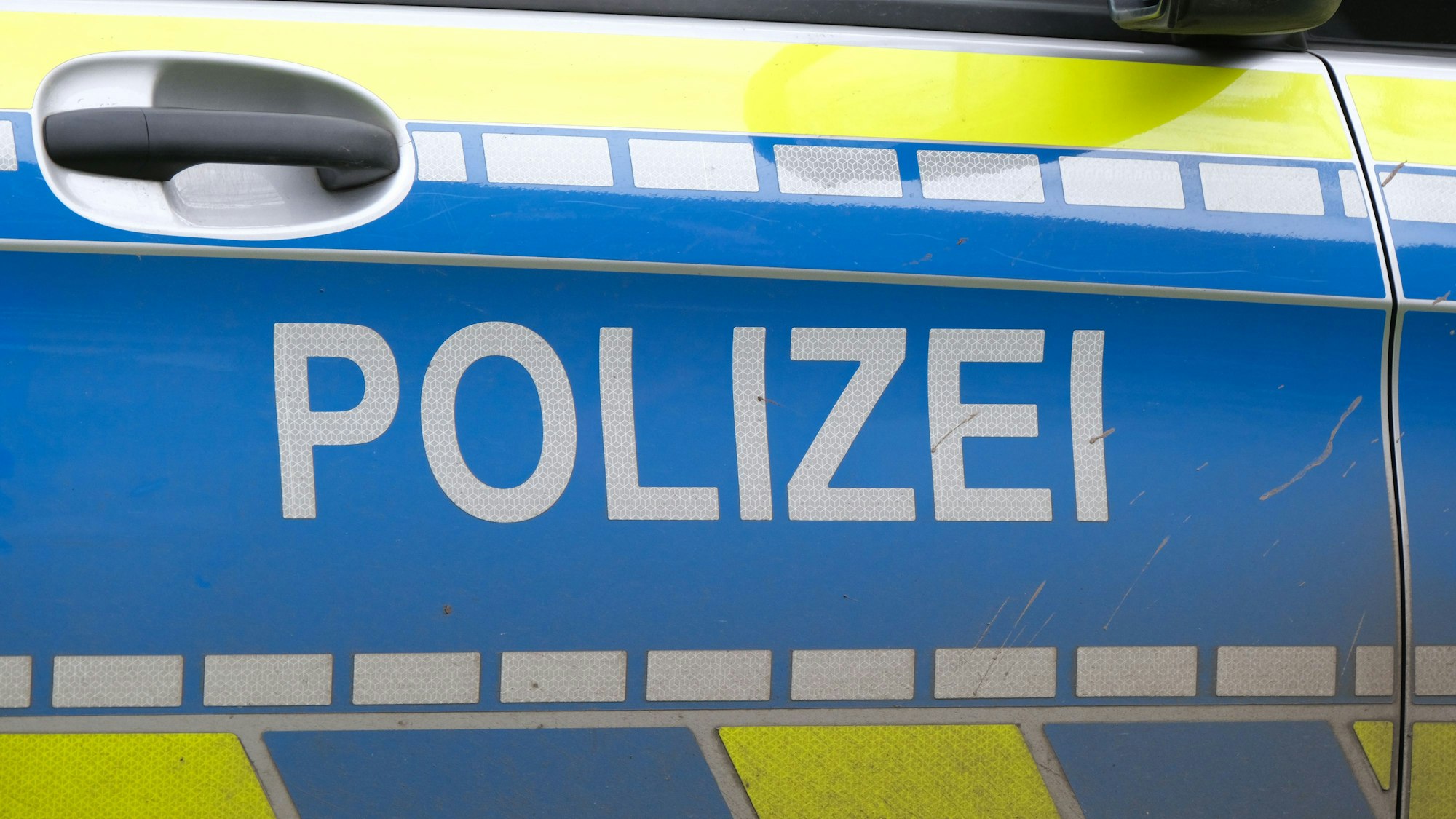 Wagentür eines Polizeiautos mit der Aufschrift „Polizei“ (Symbolbild)