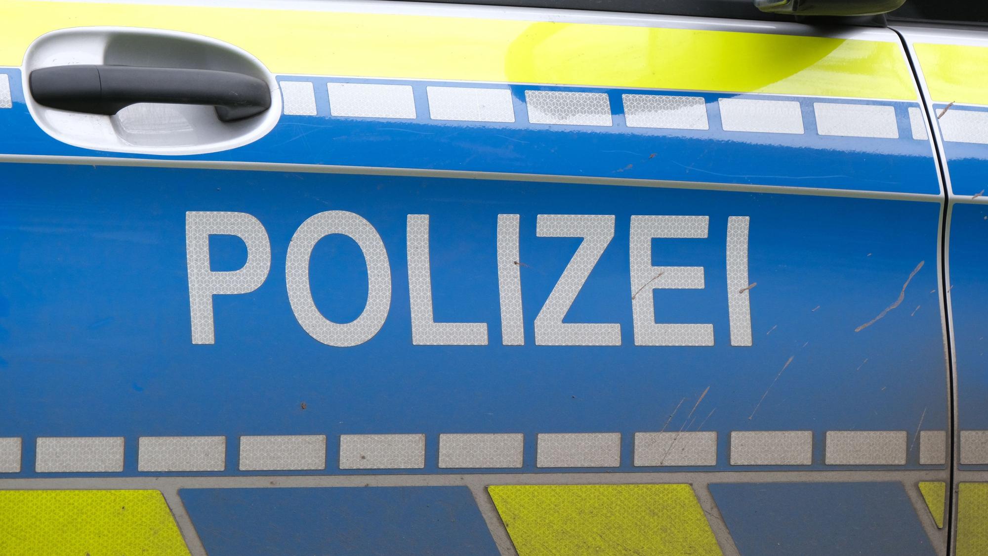 Autotür eines Polizei-Fahrzeugs mit weißer Aufschrift „Polizei“ auf blau.