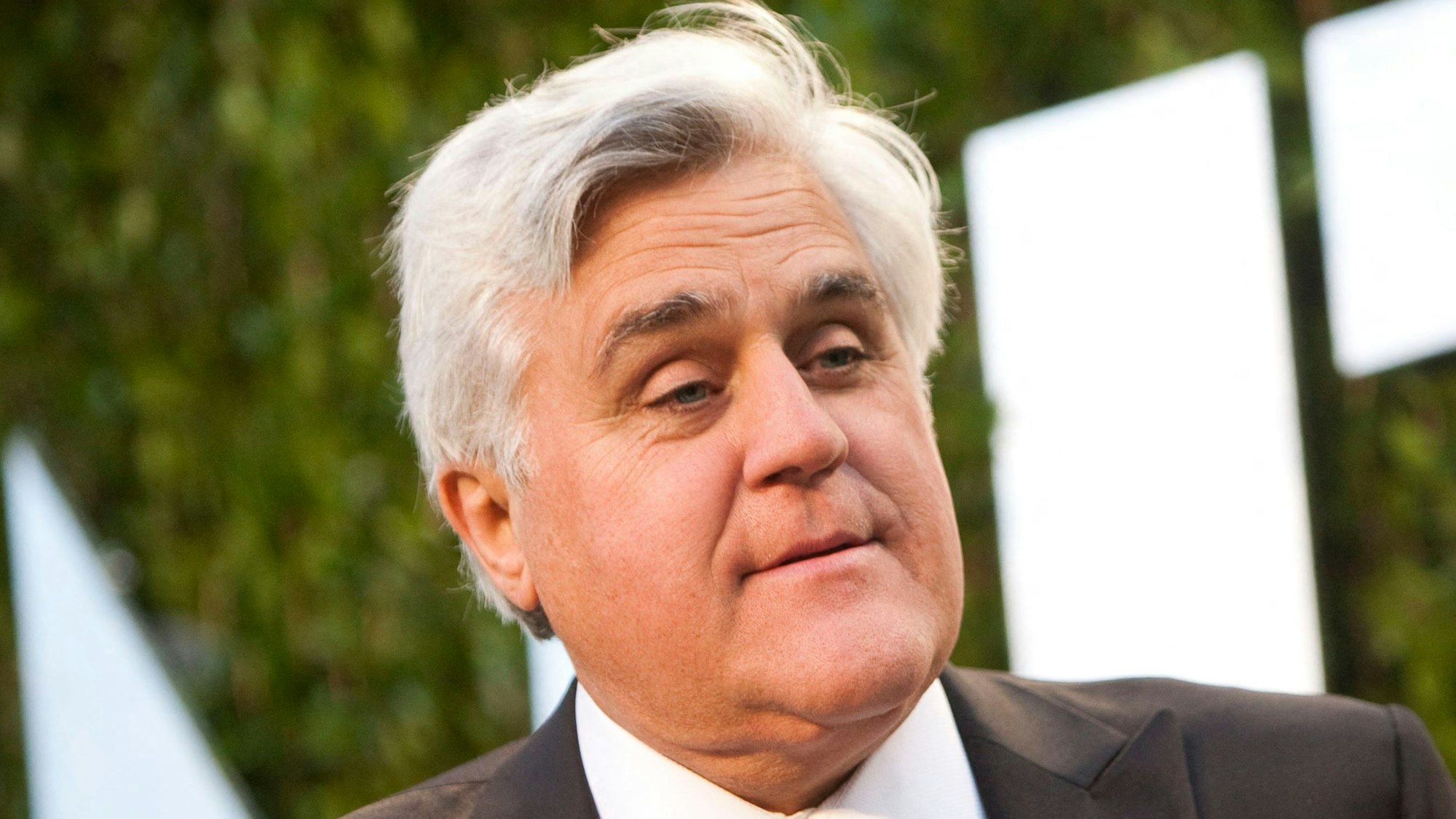 Der US-Entertainer Jay Leno lacht auf dem roten Teppich.