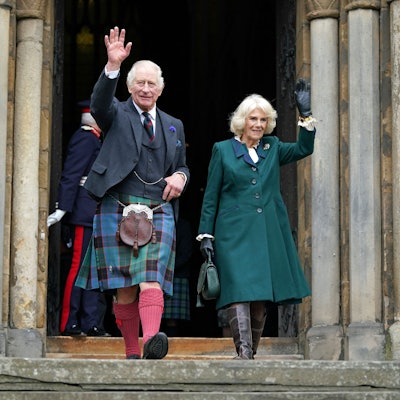 König Charles III. im Schottenrock und Königsgemahlin Camilla winken beim Verlassen der Abbey von Dunfermline.