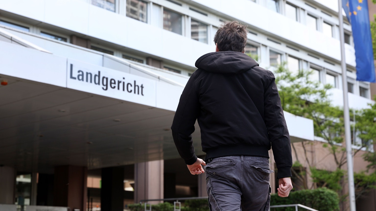 Ein Mann geht auf den Eingang zum Landgericht Köln zu.