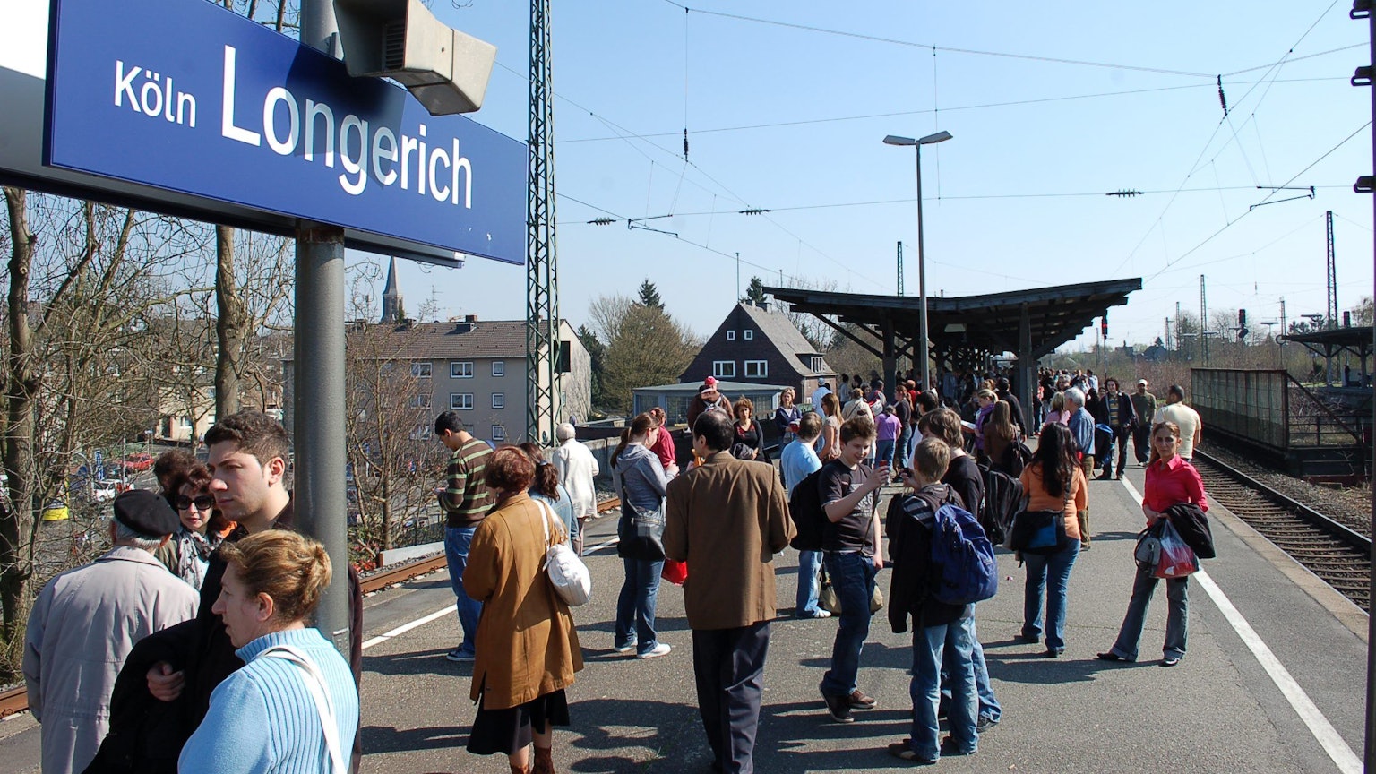 An der S-Bahnstation Longerich stehen viele Passagiere und warten auf die Bahn.