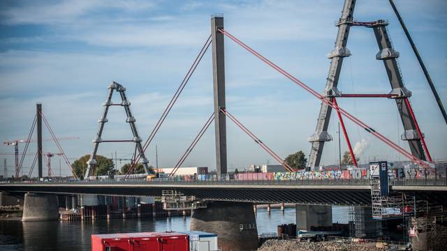 Die neue Rheinbrücke für die Autobahn 1 zwischen Köln und Leverkusen im Oktober 2022. Ein Pylon steht, ein zweiter wird gerade aufgebaut. Dazu hängt ein Kran eine Arbeitsplattform ein.