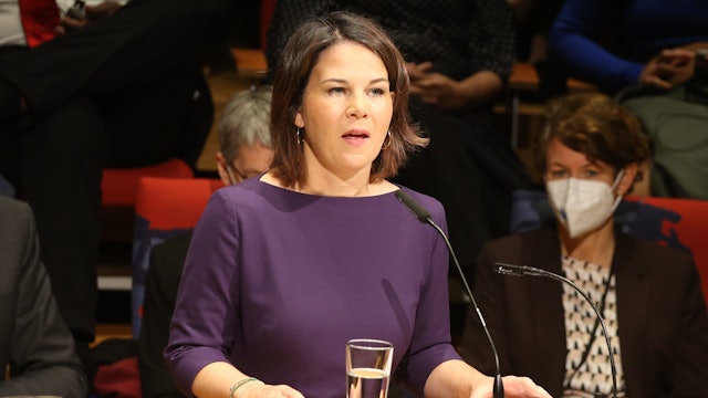 Außenministerin Annalena Baerbock spricht auf dem 8. Weltkongress gegen die Todesstrafe Sie steht in einem blauen Kleid an einem Rednerpult mit Mikrofonen.