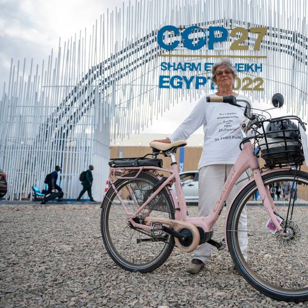 Es ist Frau Hildebrandt mit ihrem Fahrrad zu sehen, wie sie vor dem Eingang des UN-Klimagipfels steht.