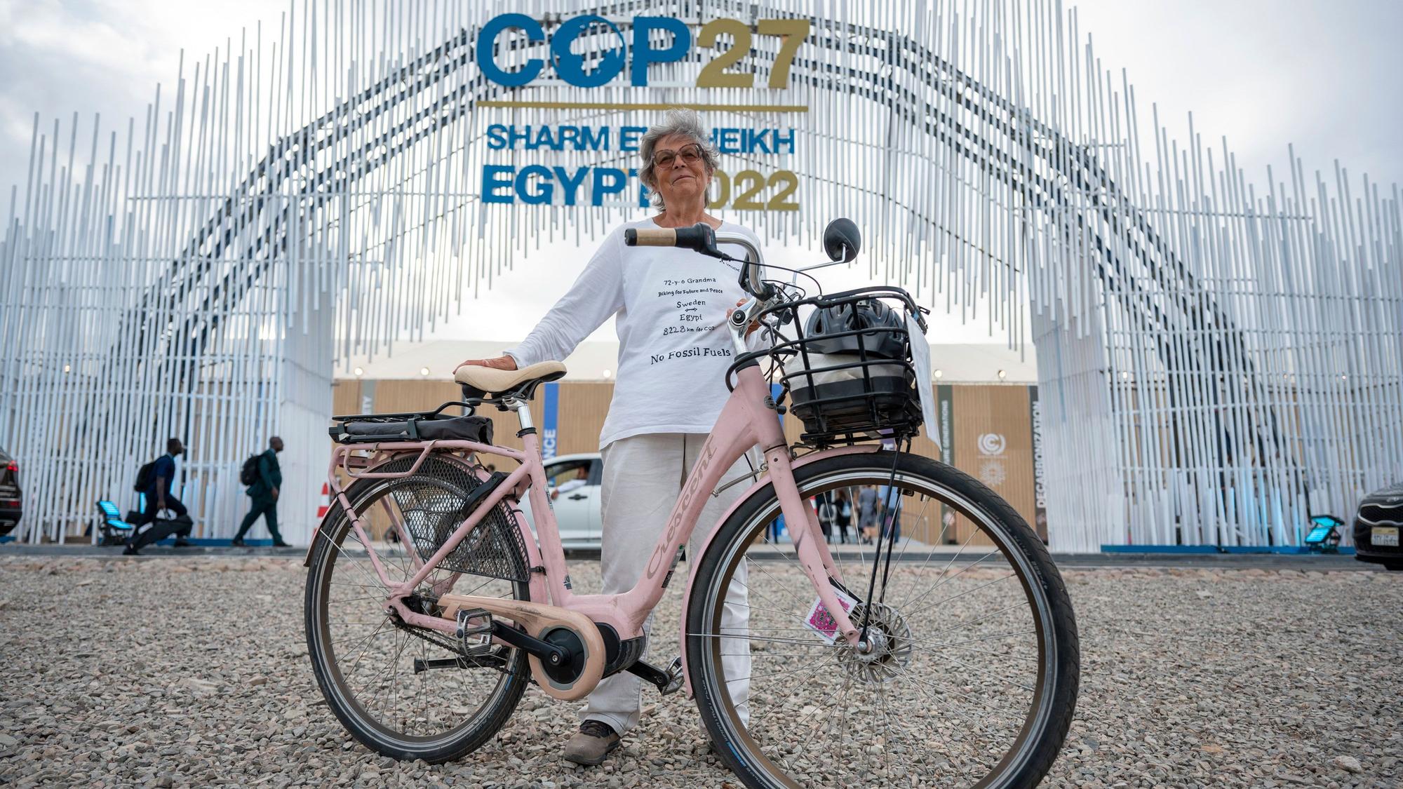 Es ist Frau Hildebrandt mit ihrem Fahrrad zu sehen, wie sie vor dem Eingang des UN-Klimagipfels steht.