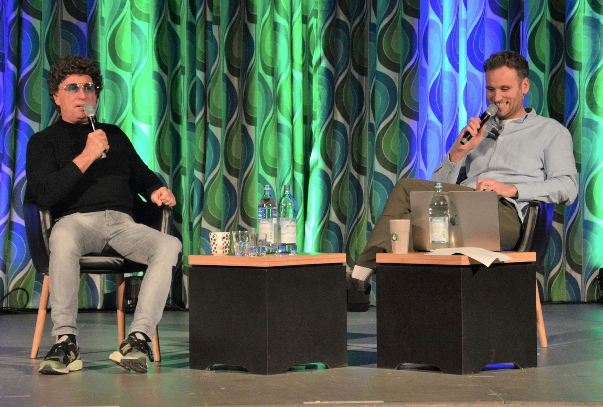 Atze Schröder (l.) und Leon Windscheid sitzen auf der Bühne im Kino in Schleiden-Vogelsang.