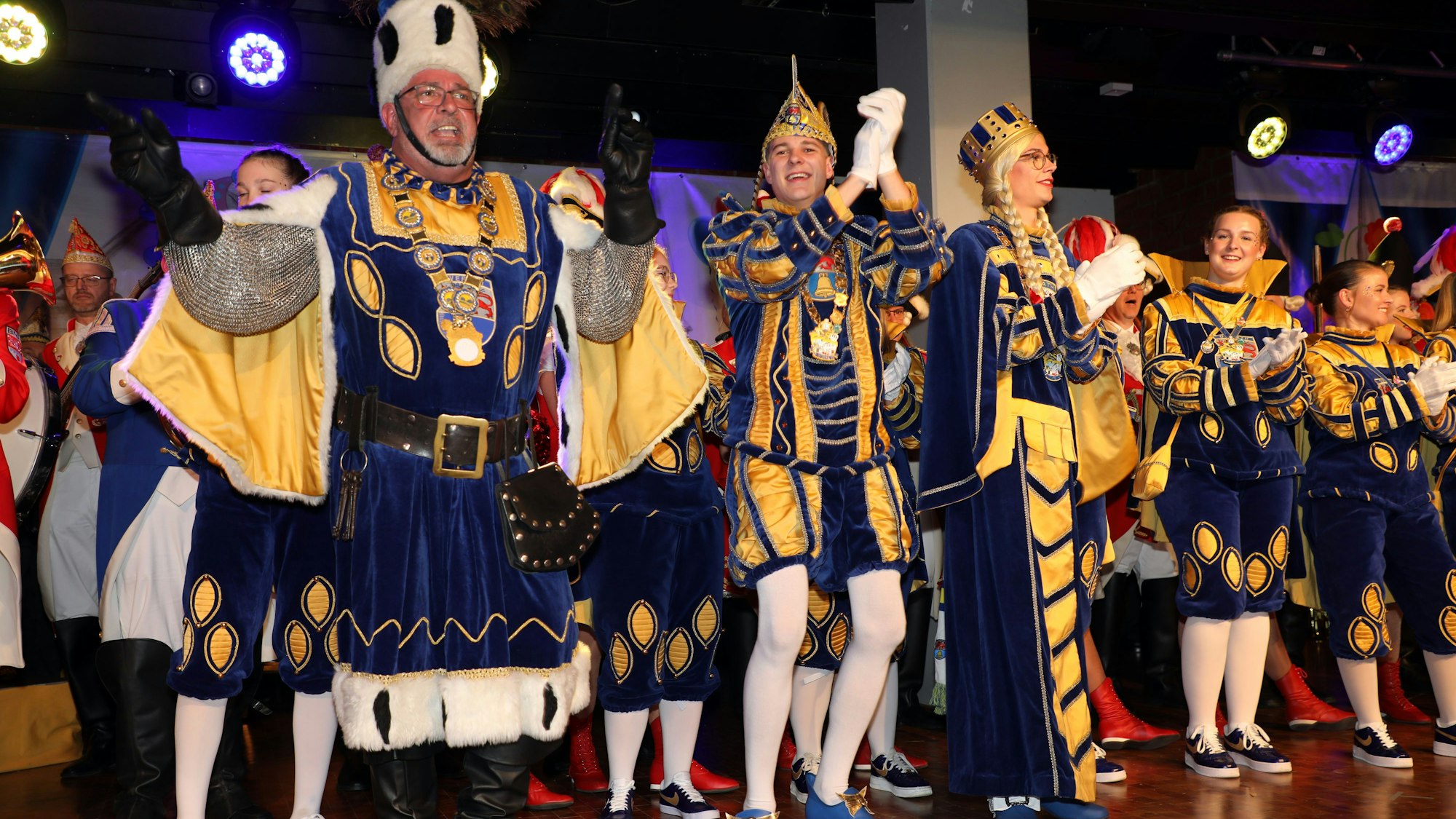 Overaths neues Dreigestirn tanzt bei der Proklamation auf der Bühne der Cyriax-Aula.