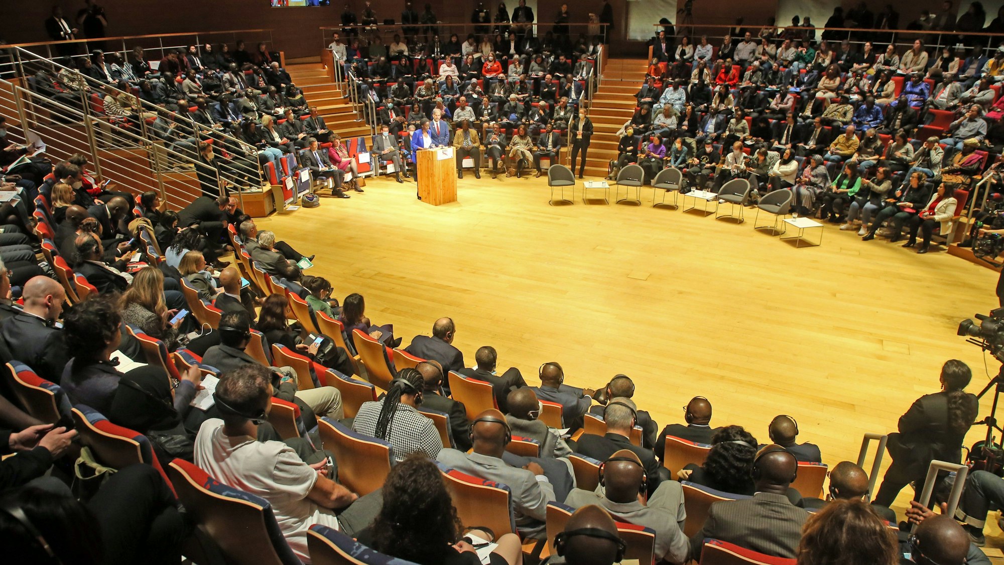 Teilnehmer verfolgen auf dem 8. Weltkongress gegen die Todesstrafe die Redebeiträge. Sie sitzen in einer großen Runde auf Stühlen, im Zentrum steht ein Rednerpult.