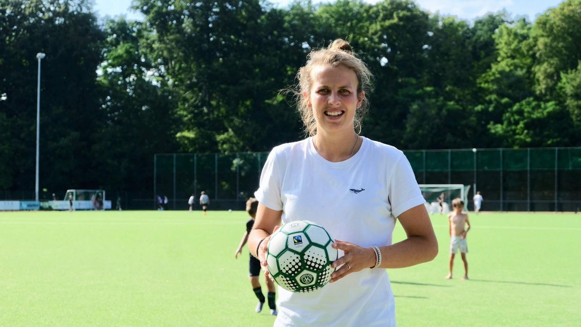 Die zweite Vorsitzende des Vereins Vorwärts Spoho Lea Wippermann mit einem Fußball auf dem Platz.