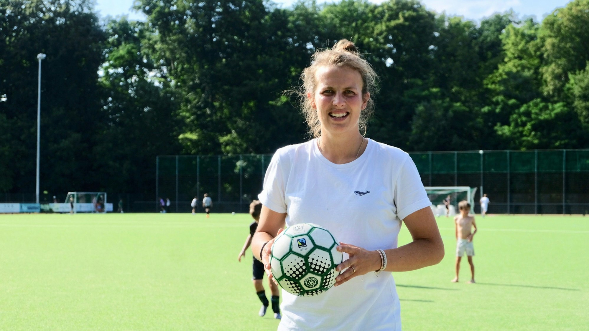 Die zweite Vorsitzende des Vereins Vorwärts Spoho Lea Wippermann mit einem Fußball auf dem Platz.