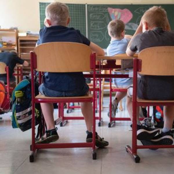 Kinder sitzen in einem Klassenraum.