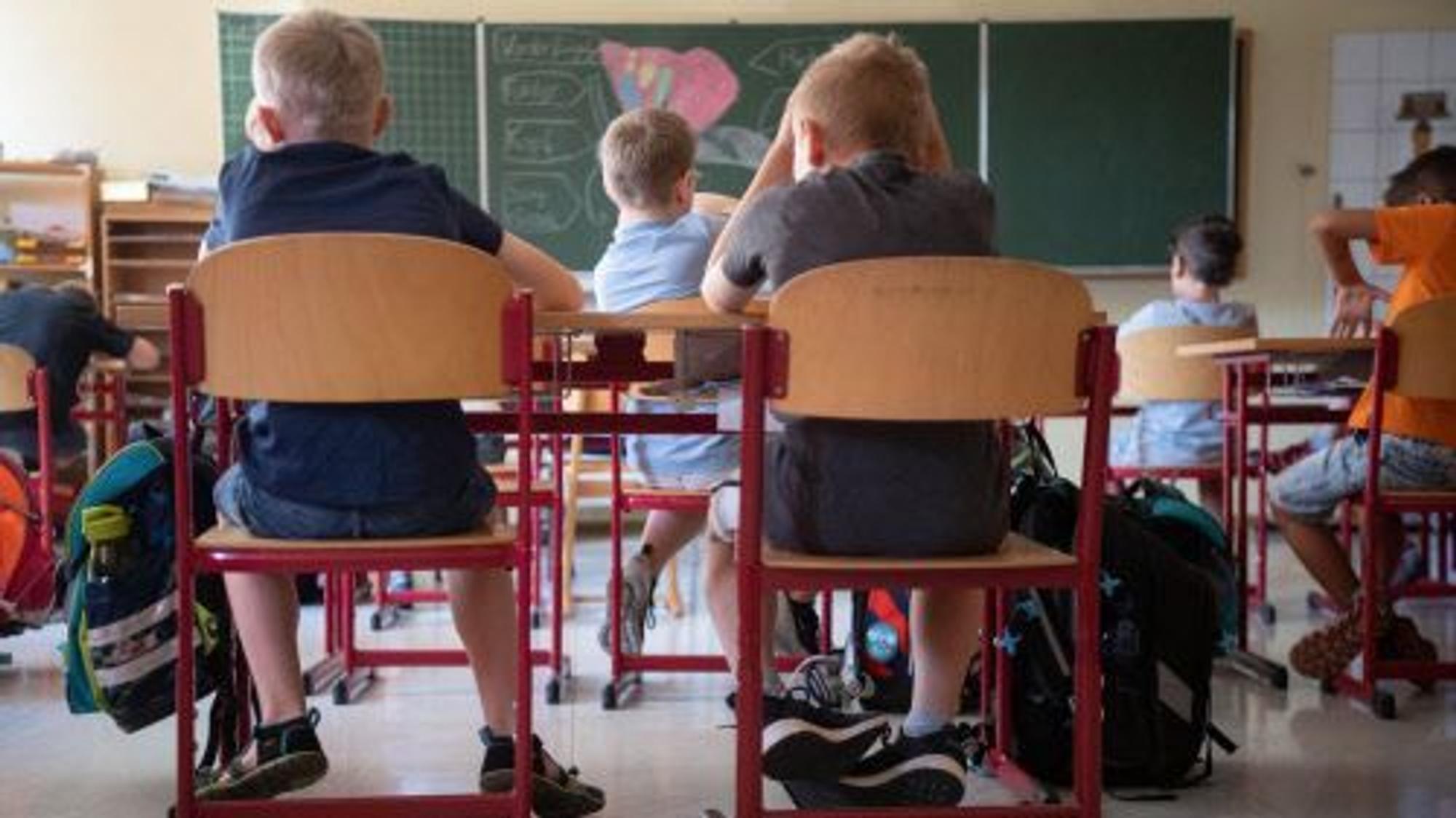 Kinder sitzen in einem Klassenraum.