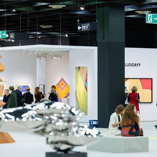 Besucher der Art Cologne gehen durch eine Messehalle der Kunstmesse Art Cologne.