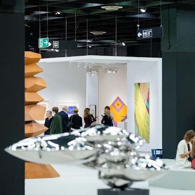 Besucher der Art Cologne gehen durch eine Messehalle der Kunstmesse Art Cologne.