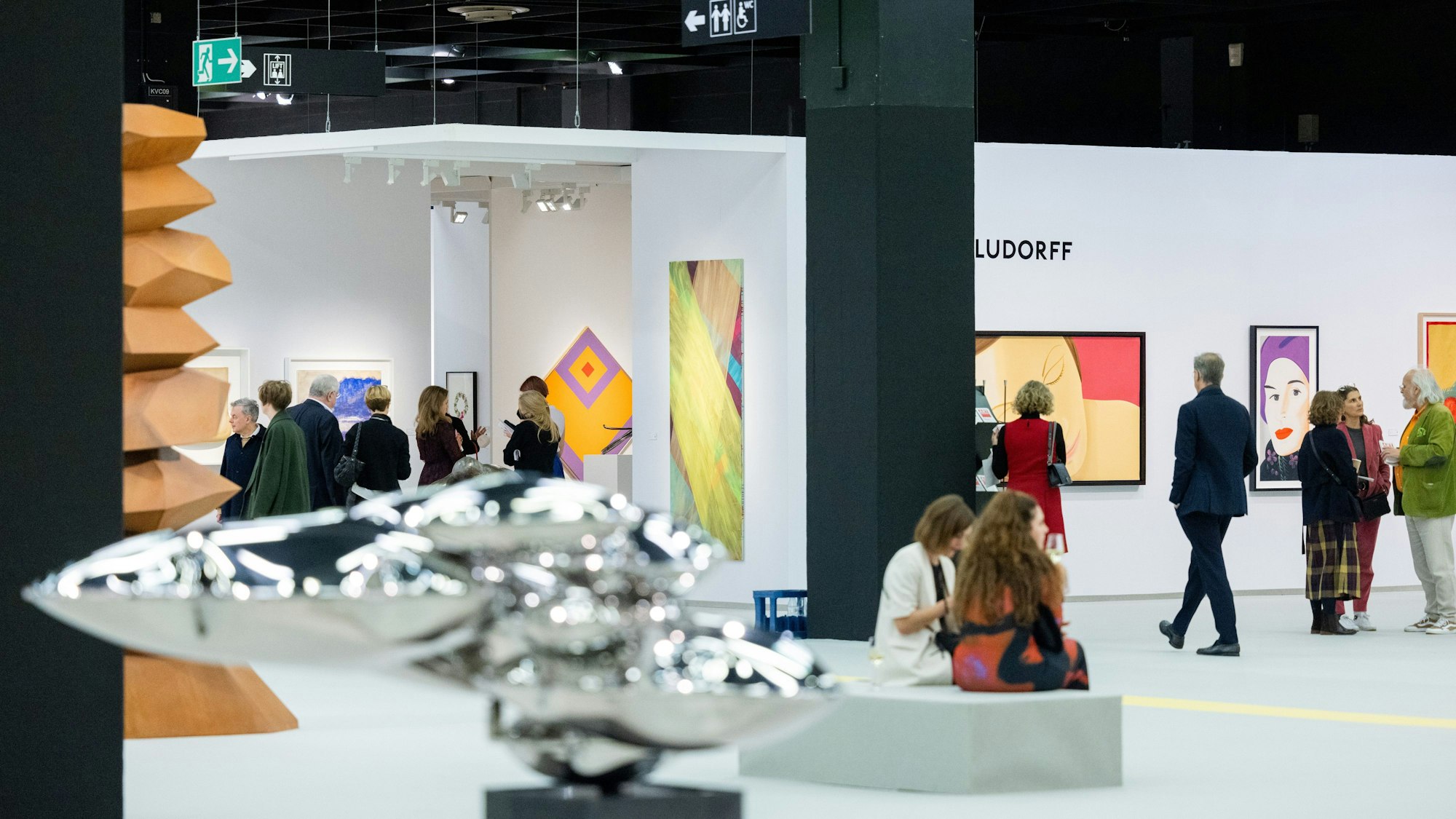 Besucher der Art Cologne gehen durch eine Messehalle der Kunstmesse Art Cologne.